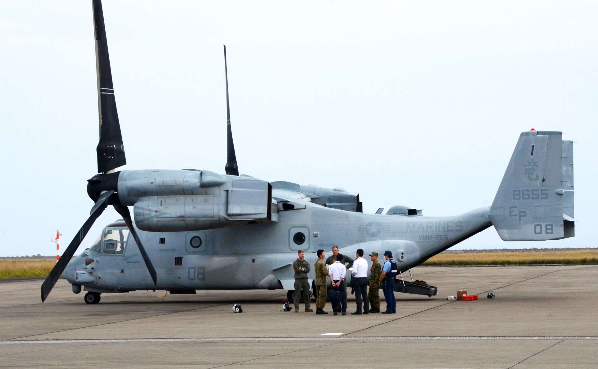 〈資料写真〉２０２４年１１月１４日、緊急着陸したオスプレイの前で米軍に状況を聞く陸自隊員ら＝奄美市の奄美空港