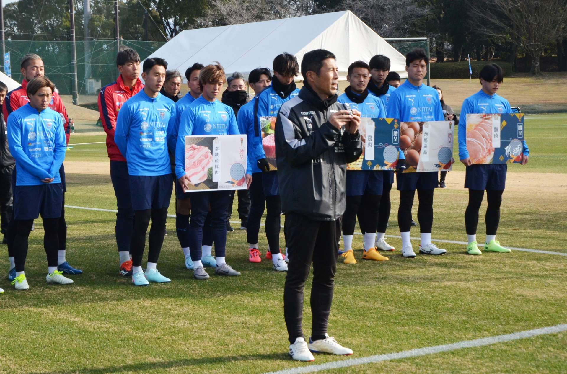 横浜ＦＣの選手・スタッフを代表してあいさつする四方田修平監督（中央）＝１４日、都城市高城運動公園