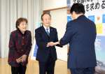 拉致被害者の救出を求める署名簿を受け取る市川健一さん、龍子さん夫妻＝１６日、指宿市の指宿保健センター