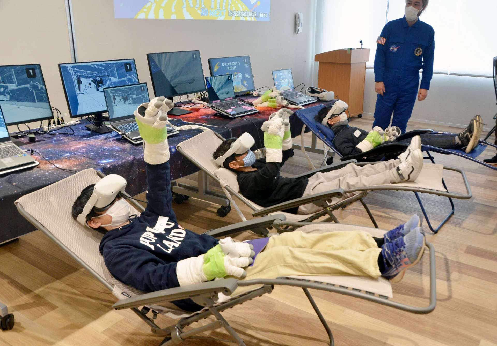 ＶＲゴーグルを着用して宇宙空間を疑似体験する児童＝都城市都北町の道の駅「都城ＮｉＱＬＬ」