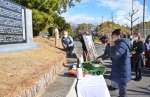 阪神大震災の犠牲者を悼み献花する鹿児島県人会の会員ら＝１７日、神戸市中央区の大倉山公園