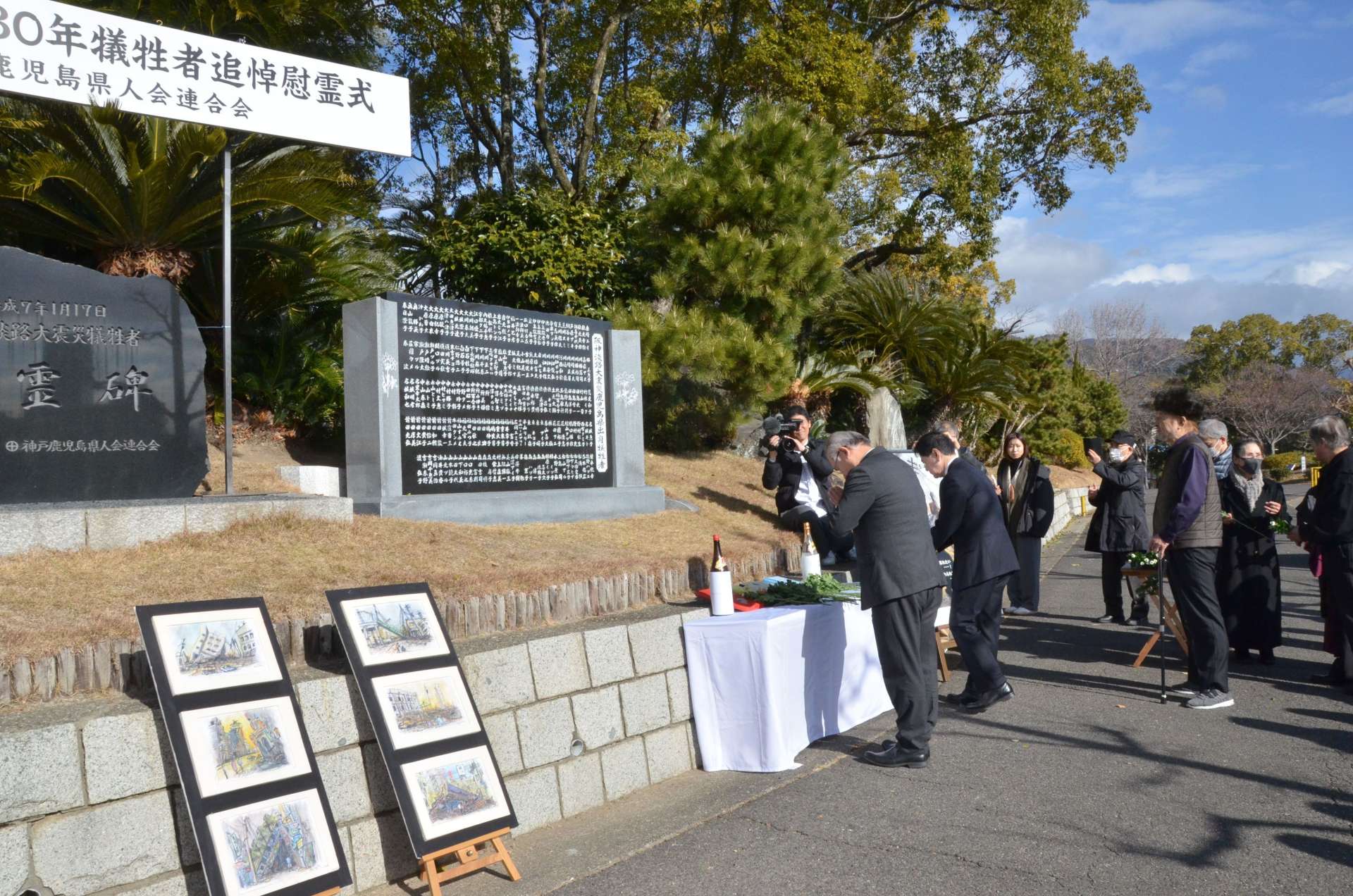 阪神大震災の犠牲者を悼み献花する鹿児島県人会の会員ら＝１７日、神戸市中央区の大倉山公園