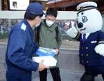 １１８番をＰＲする海上保安庁のマスコット「うみまる」と海上保安官＝１７日、鹿児島市のＪＲ鹿児島中央駅