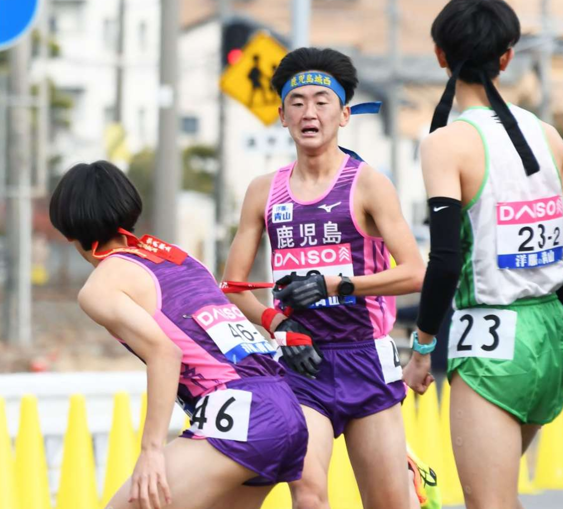 鹿児島の１区櫨元（鹿城西高、中央）が２区碇元（田検中）にたすきをつなぐ＝広島市