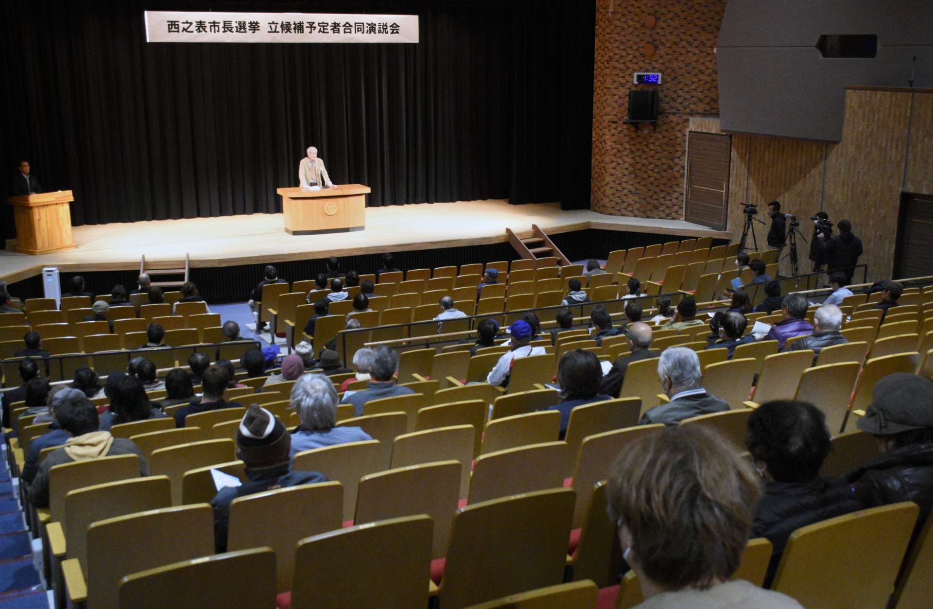 立候補予定者の演説の前にあいさつする主催者＝１９日、西之表市民会館
