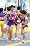 鹿児島の１区櫨元（鹿城西高、左）が２区碇元（田検中）にたすきリレー＝広島市西区