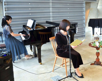 椋鳩十の「熊野犬」を朗読する藤田雅子さん（右）＝鹿児島市荒田１丁目のイイテラス