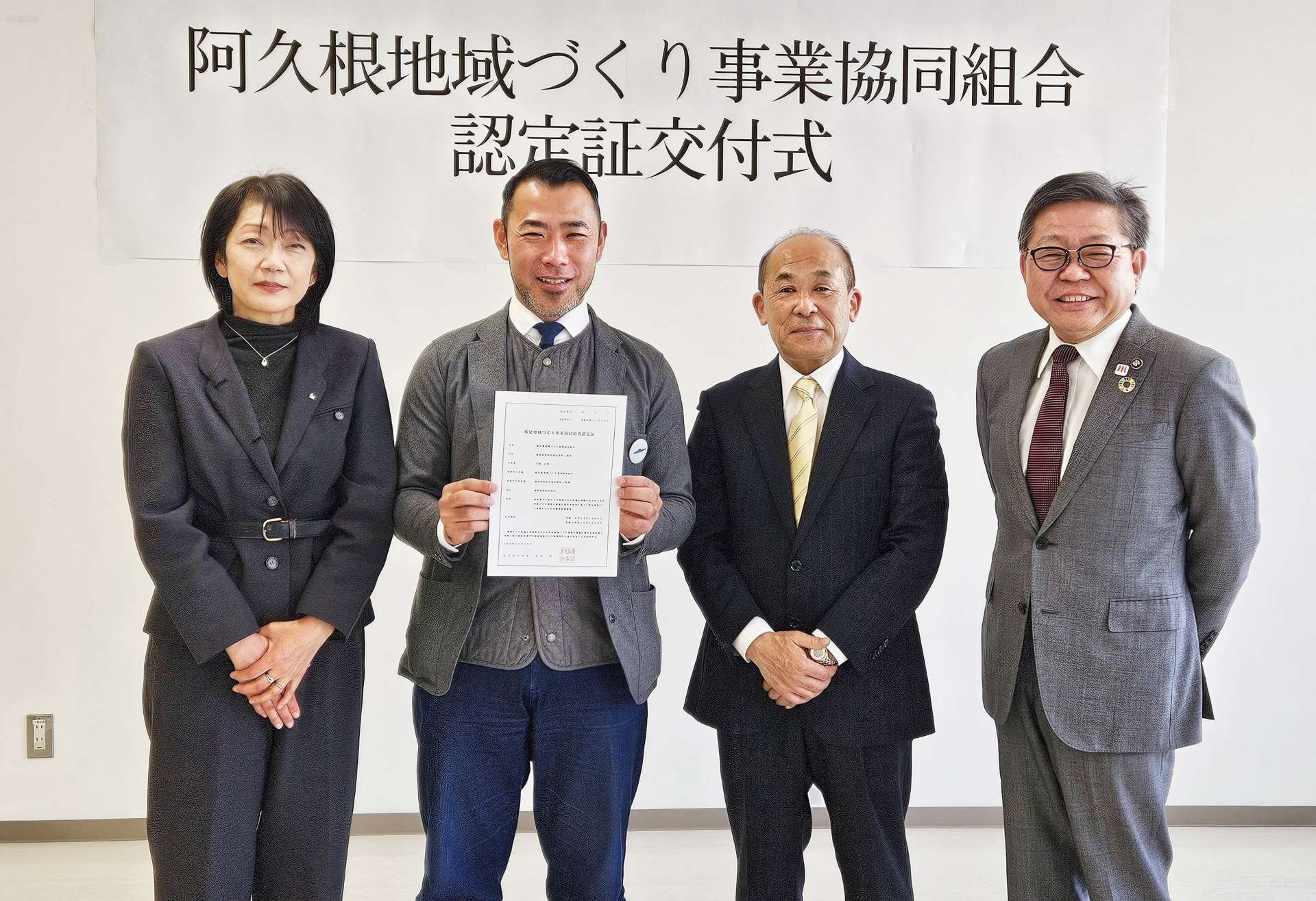 認定証を受け取り記念撮影する下園代表理事（左から２人目）ら＝薩摩川内市の県北薩地域振興局