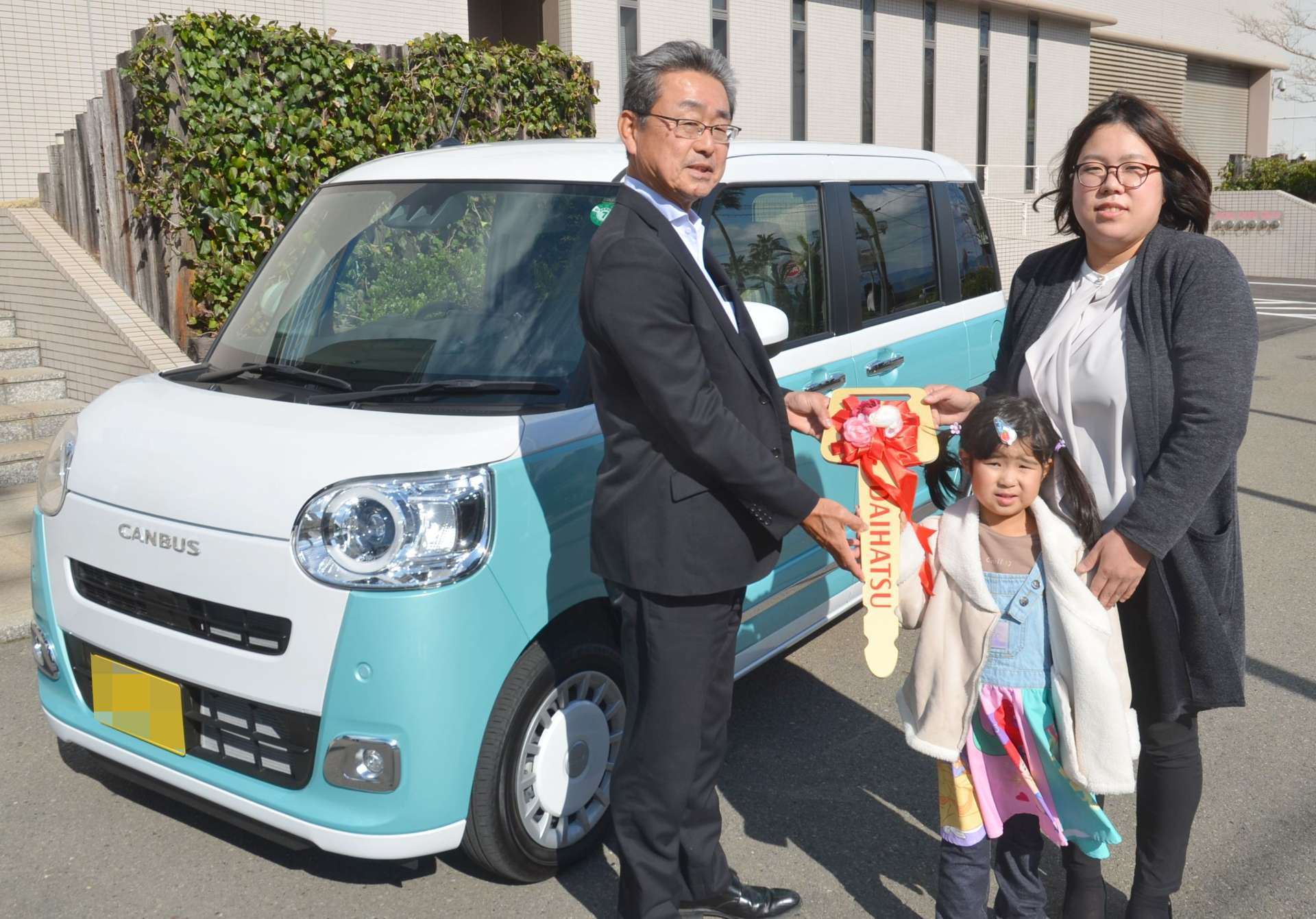 ゴールデンキーを受け取る園田加菜さん（右）＝２０日、鹿児島市の南日本新聞会館（画像は一部加工してあります）