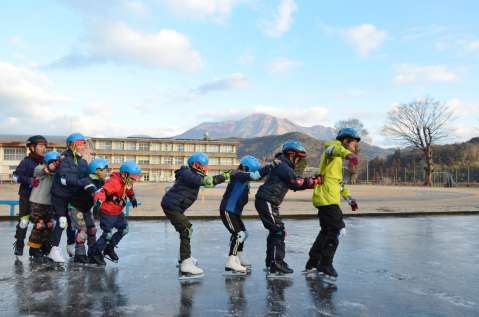 高千穂峰を背にスケートを楽しむ吉之元小学校児童＝１６日、都城市吉之元町