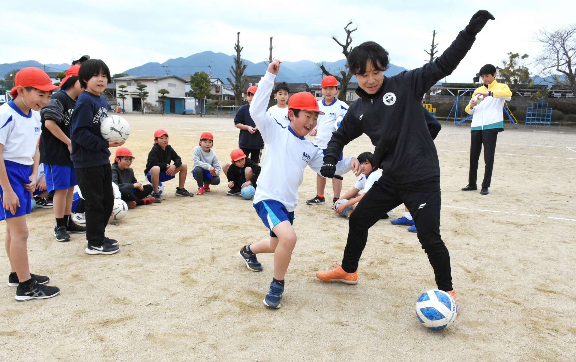 山之内大晃さん（右）からボールを奪おうとする児童＝１７日、出水市の西出水小学校