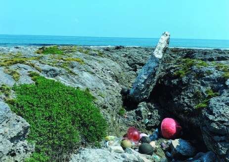 受賞作「大好きなきかい島の海」の「×」写真。海岸の岩場に散乱するごみを写した（出光興産提供）