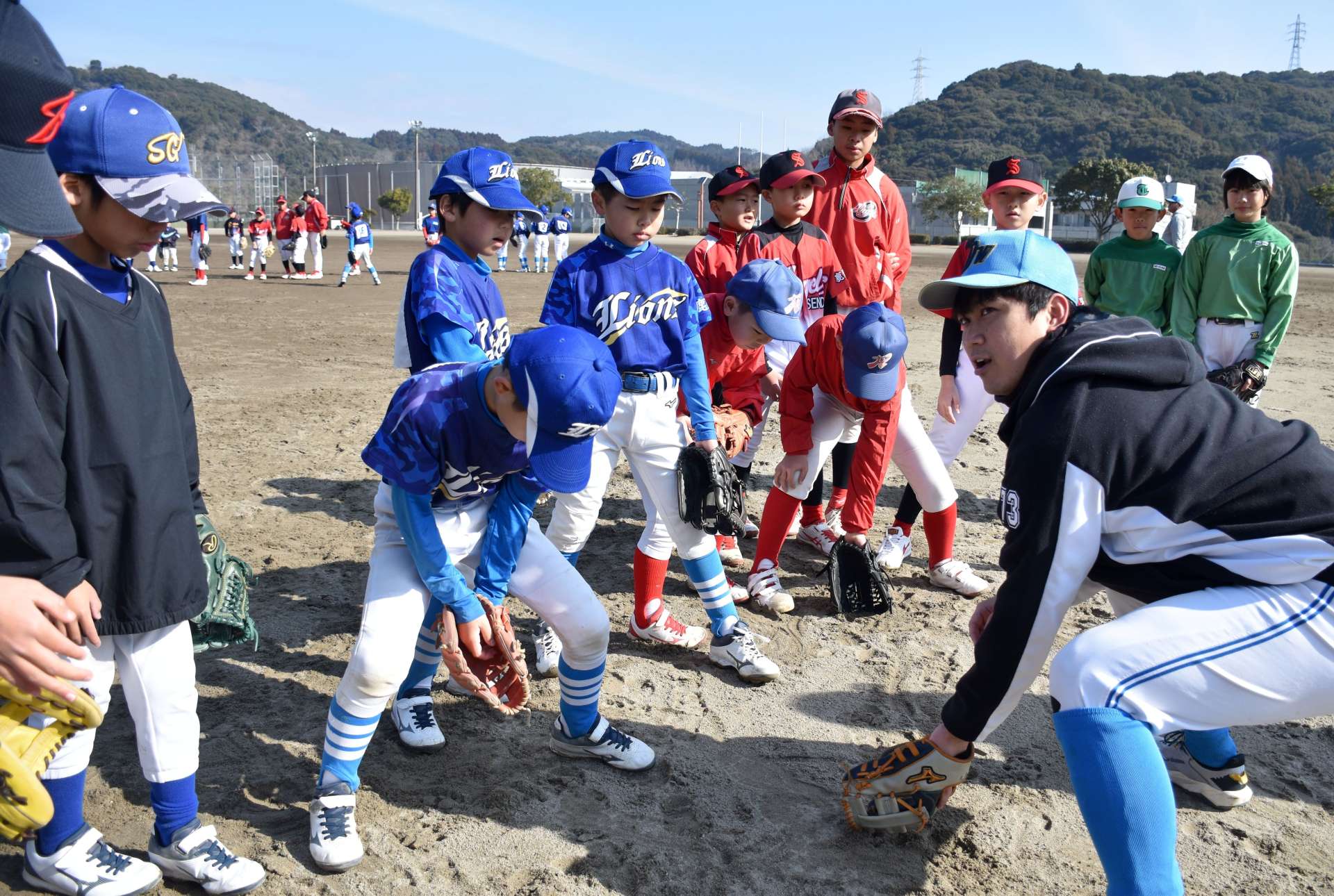 鹿児島ＤＷの選手にボールの捕り方を教わる子どもたち＝薩摩川内市総合運動公園