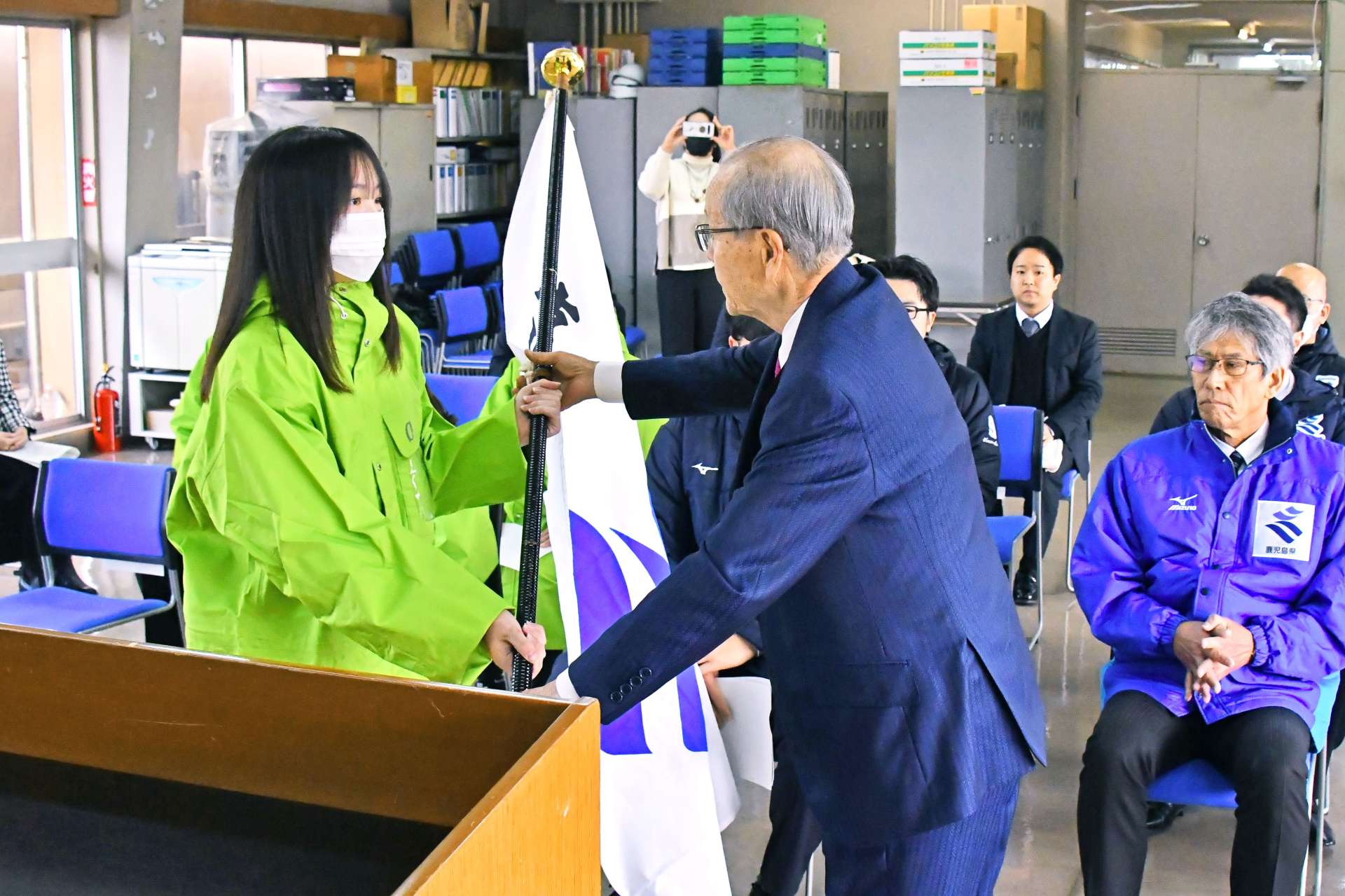 団旗を受け取る福留明莉選手（左）＝県体協会館