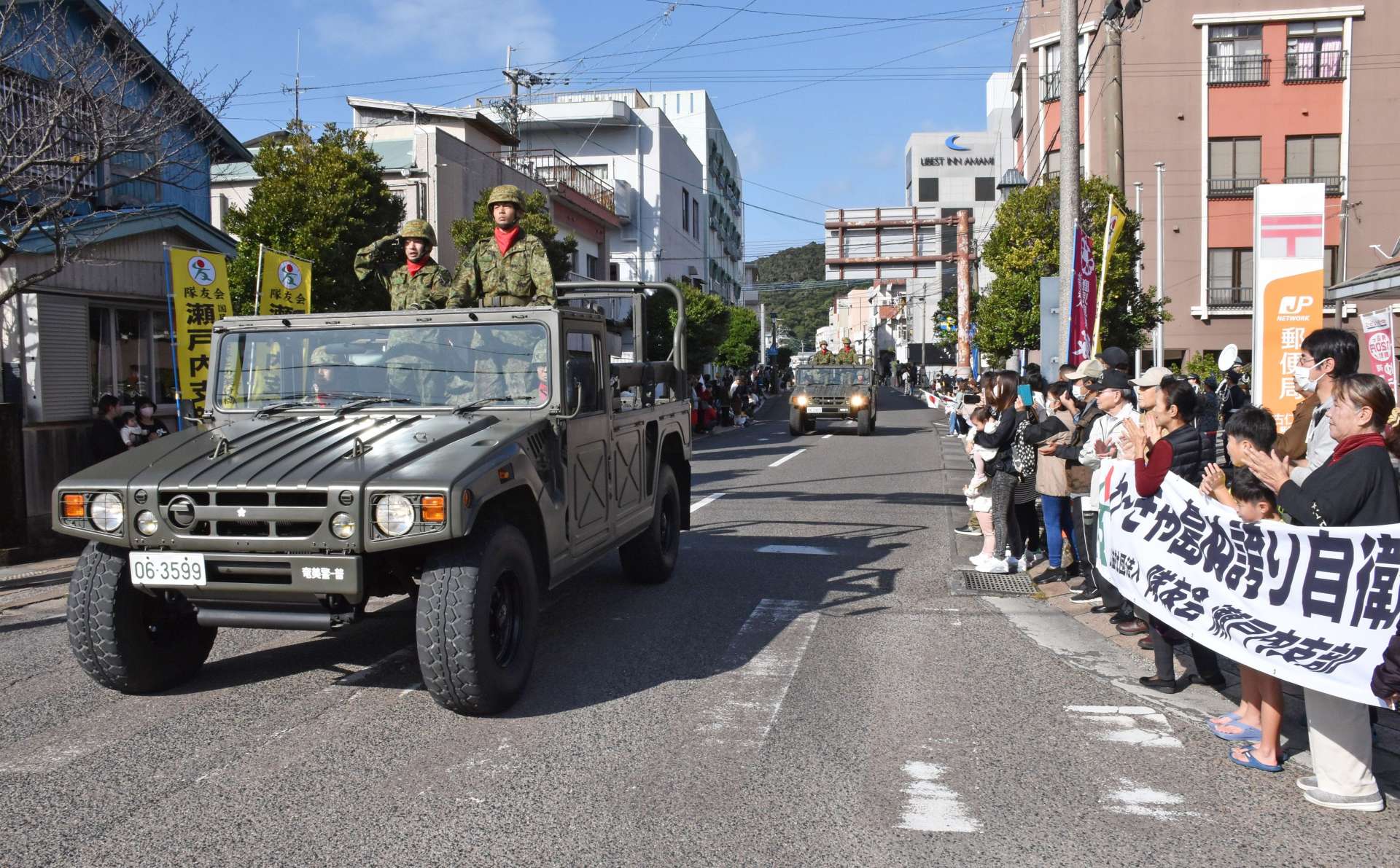 目抜き通りをパレードする陸上自衛隊の車両＝２６日、瀬戸内町古仁屋