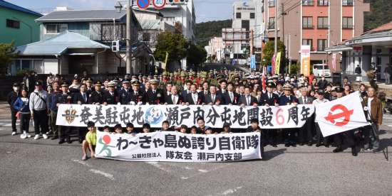 パレードを終え、住民らと記念撮影する陸海空３自衛隊＝２６日、瀬戸内町古仁屋
