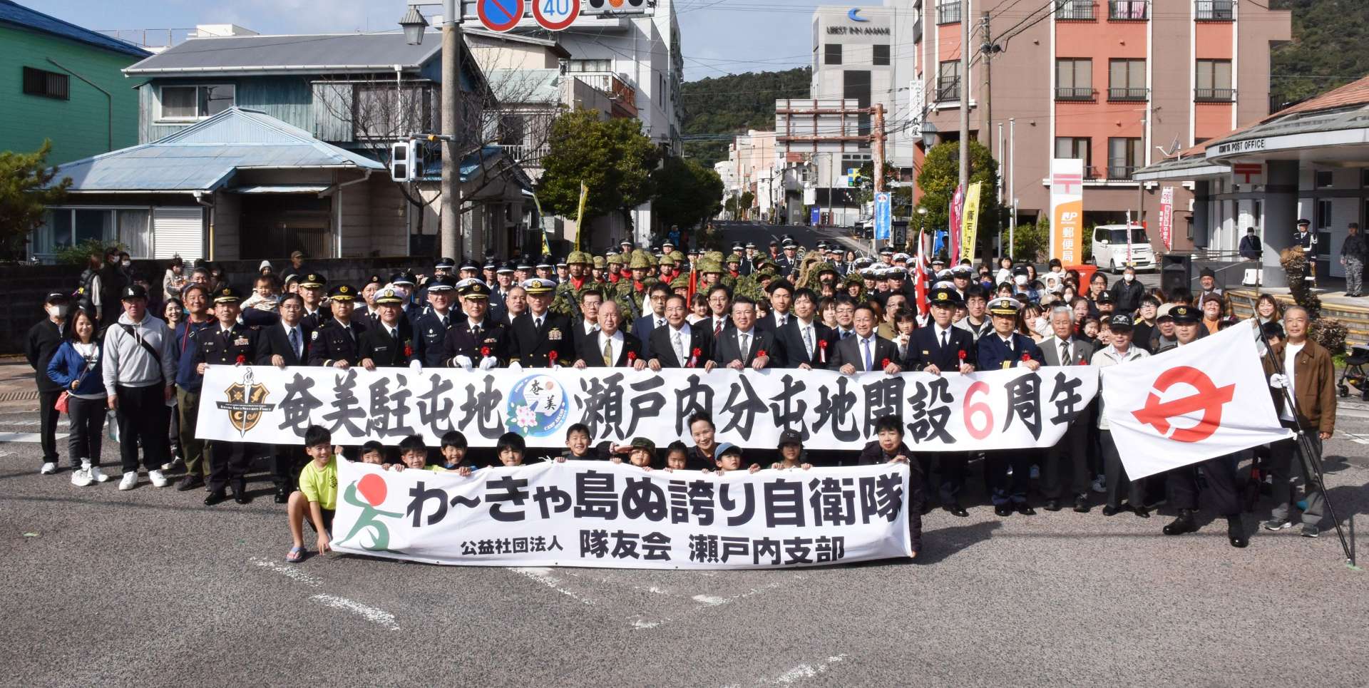 パレードを終え、住民らと記念撮影する陸海空３自衛隊＝２６日、瀬戸内町古仁屋