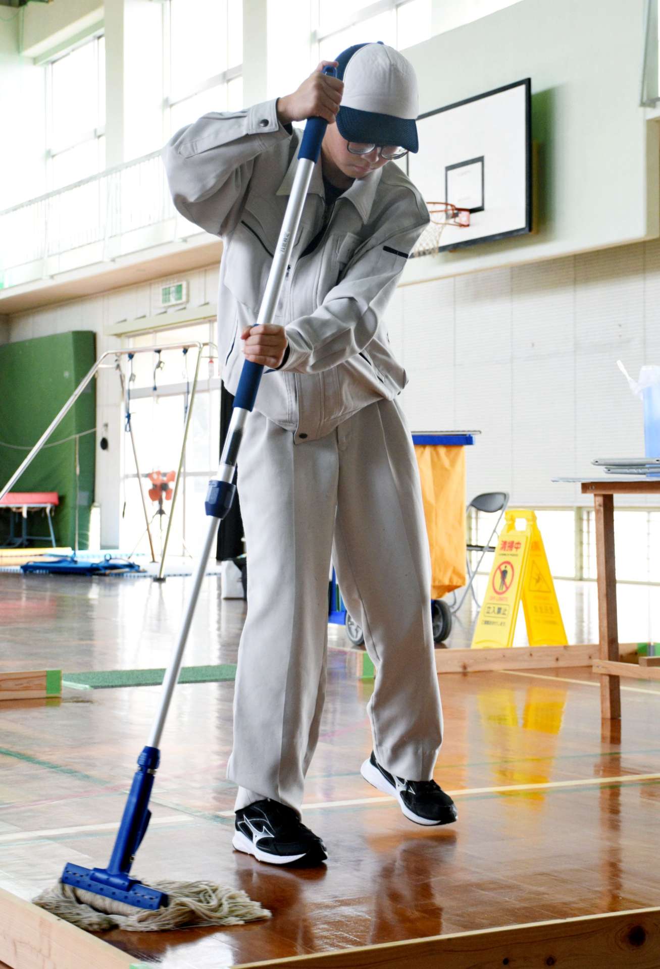 てきぱきとした動きで床を磨く宮田小春さん＝中種子町の中種子特別支援学校