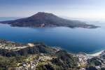 上空から望む桜島と鹿児島湾（鹿児島市提供）