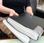 告発のために集めた資料を手にする４０代女性＝２０２４年１０月、志布志市内