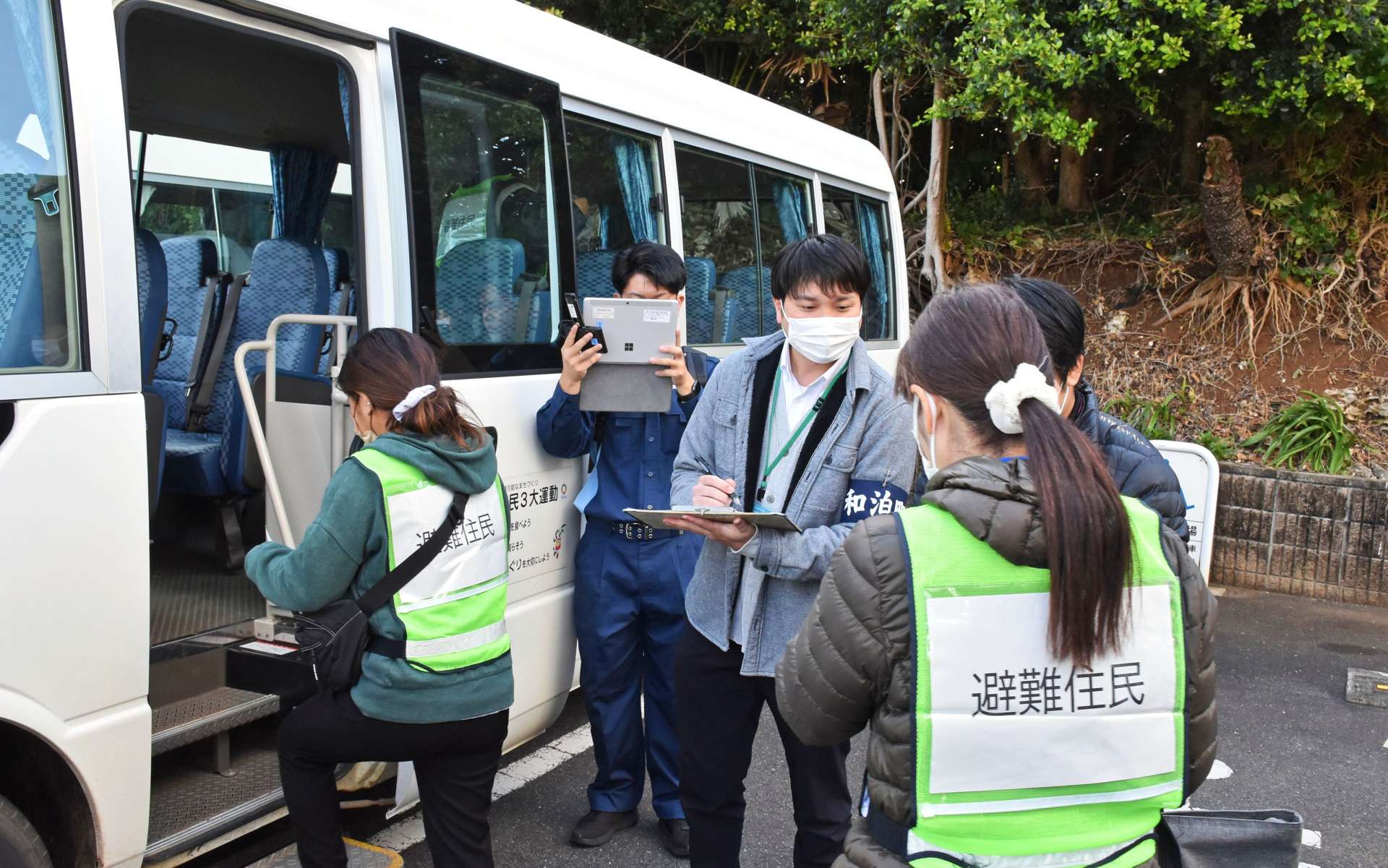 集合場所からバスに乗り込み、避難する住民＝２８日、和泊町和泊