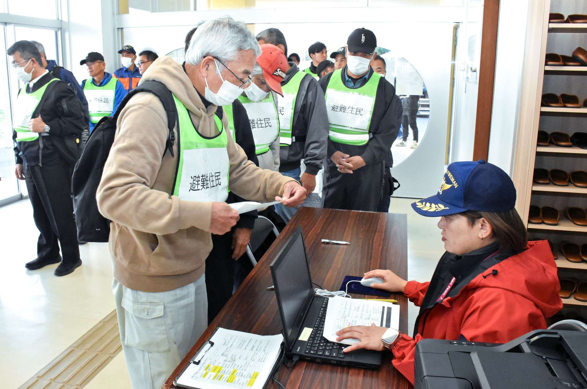 集合場所で本人確認をする住民＝２８日、和泊町和泊