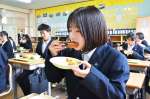 地元産の黒豚を使ったメンチカツを味わう生徒＝薩摩川内市の入来中学校