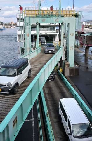 桜島フェリーから下船する車両＝２９日午後、鹿児島市の鹿児島港桜島フェリーターミナル