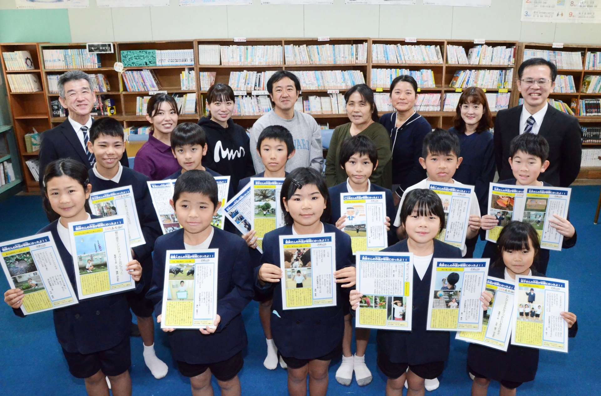 ２年連続の全員掲載を喜ぶ児童と教諭ら＝伊仙町の馬根小学校