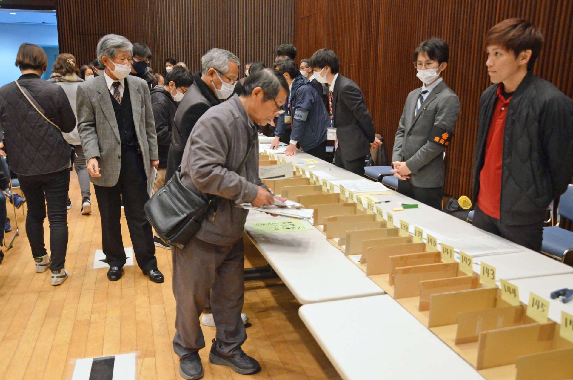 目当ての品に札を入れる来場者＝３０日、鹿児島市のカクイックス交流センター