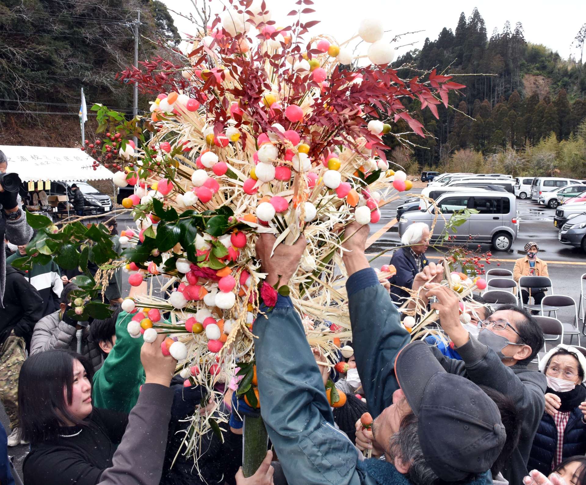無病息災を願い、華やかなダゴ花に手を伸ばす参加者＝２日、志布志市の田之浦ふるさと交流館