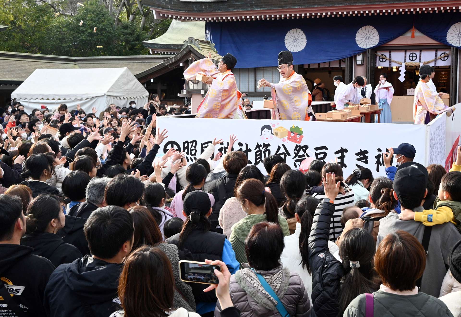 豆を取ろうと手を伸ばす参拝客ら＝２日、鹿児島市の照国神社