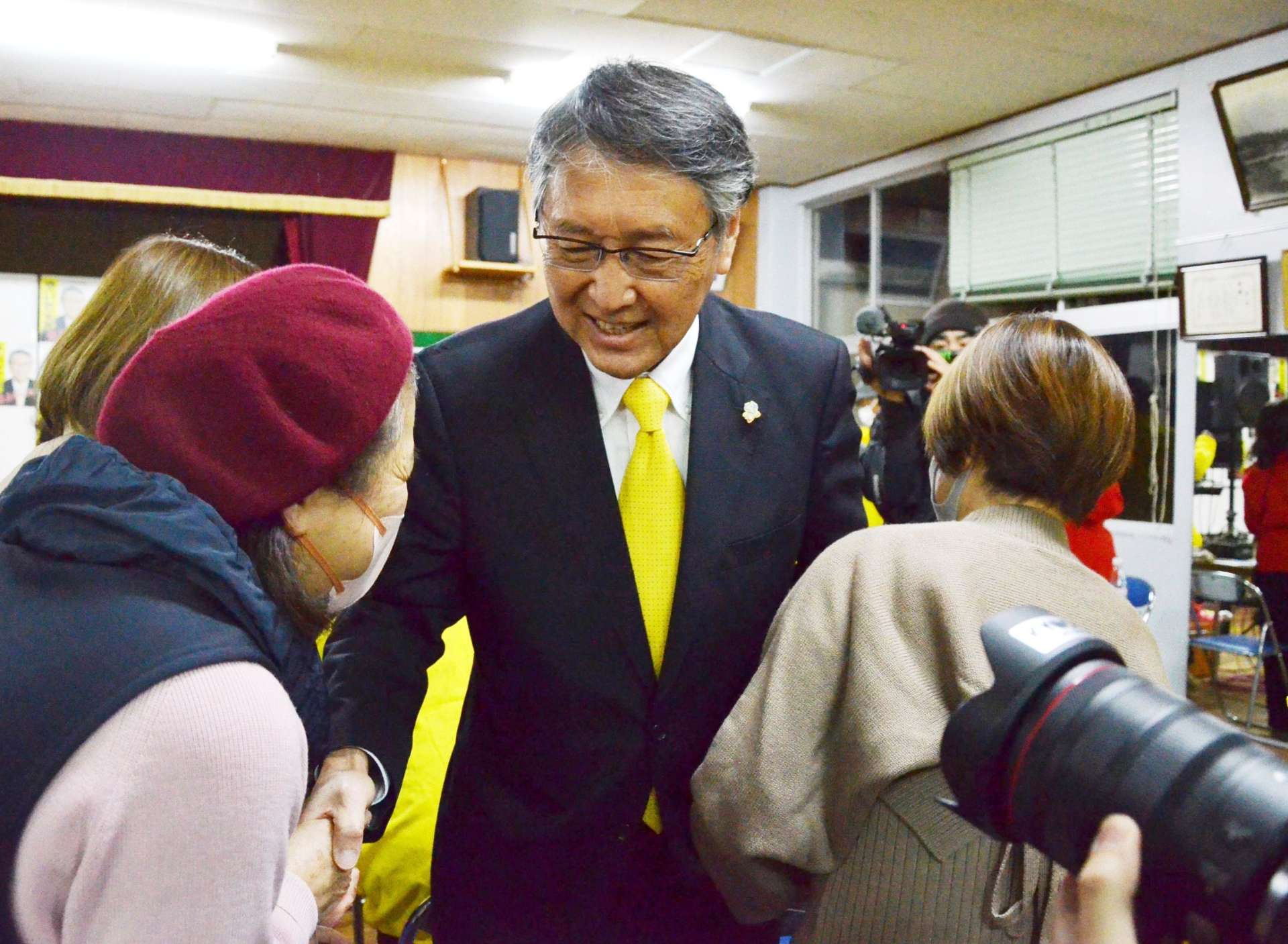 支持者と握手を交わす八板俊輔さん＝２日午後９時４３分、西之表市西町
