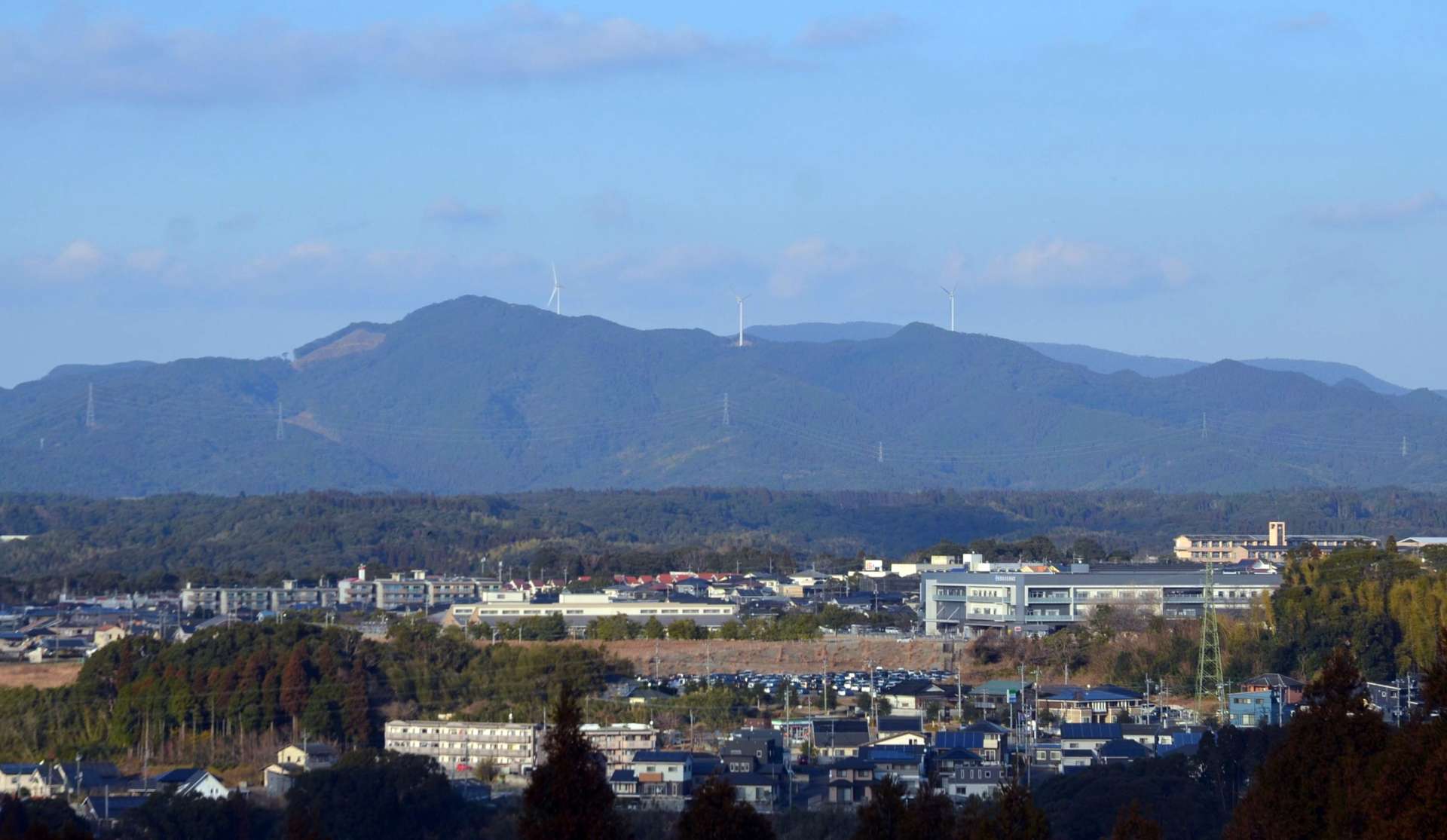 風車８基の建設が計画されている八重山周辺。手前には日置市・重平山の風車が並ぶ＝日置市伊集院の城山公園から撮影