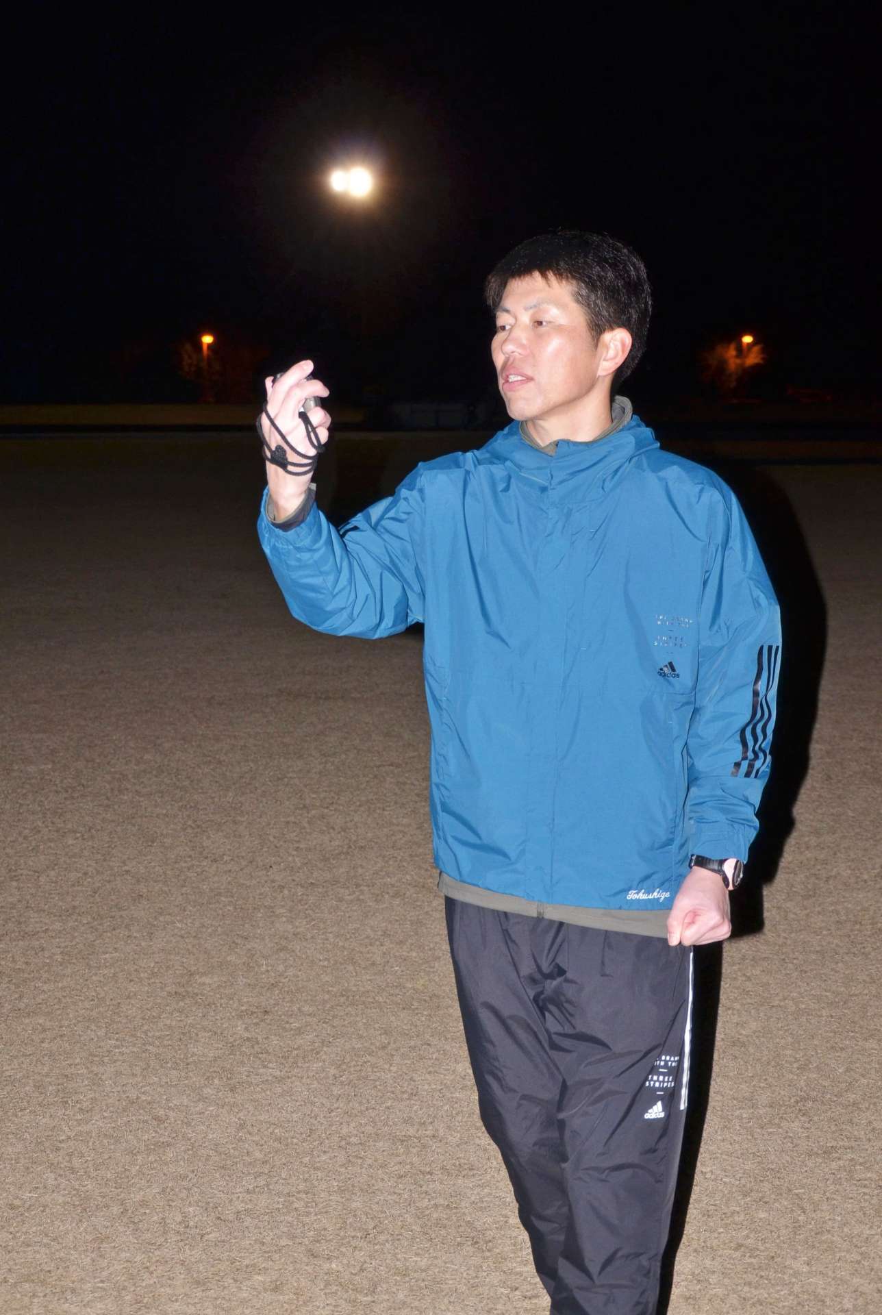 練習する選手のラップを計測する徳重祐児さん＝日置市の伊集院総合運動公園陸上競技場