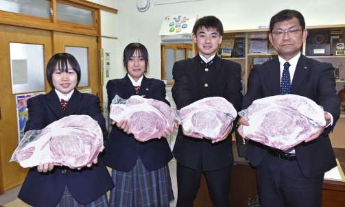 〈関連＝これが日本一に輝いた肉か…〉ロース肉を贈呈するスターゼン鹿児島営業所の神川博文所長（右）と受け取る鹿屋農業高校の生徒＝鹿屋市の同校