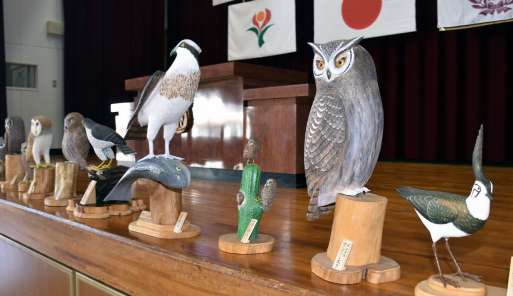 畠野尚利さんが製作した木彫りのフクロウなど＝曽於市の財部南小学校