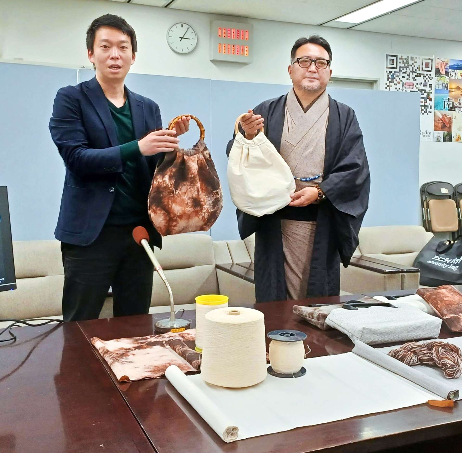 大島紬の伝統技術を使って開発した製品を説明する瀧井和篤さん（左）と大瀬輝也さん＝６日、鹿児島県庁