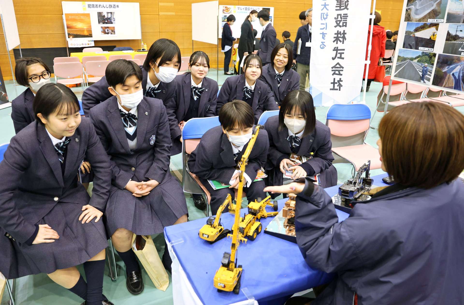企業の担当者の説明に聞き入る高校生ら＝薩摩川内市のサンアリーナせんだい