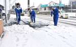 会社前の歩道の雪かきをする従業員＝８日午前、南さつま市加世田