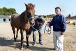 「はやて」号の世話をする釘田義人さん（右）と保存会の有馬大作会長＝鹿屋市串良