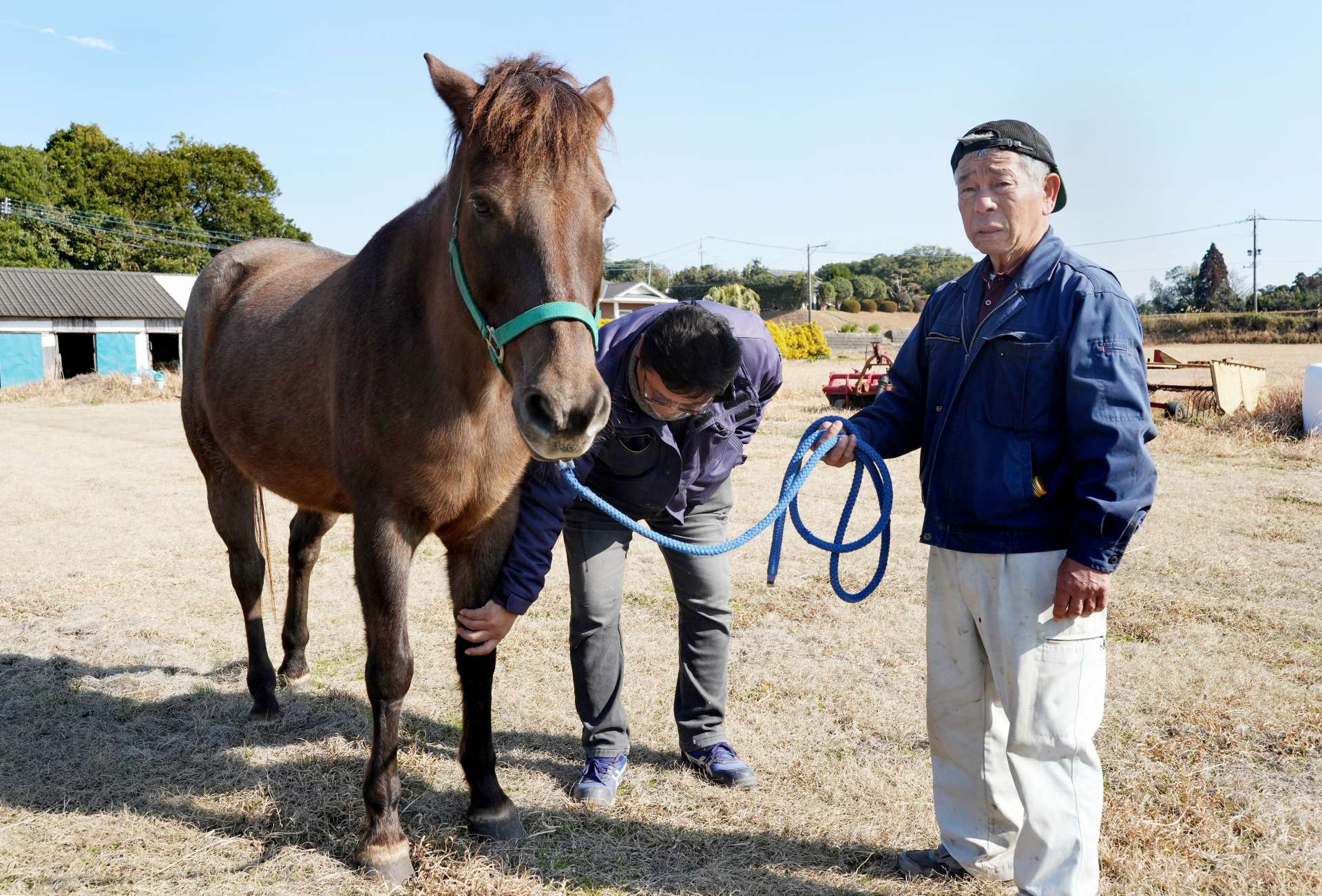 「はやて」号の世話をする釘田義人さん（右）と保存会の有馬大作会長＝鹿屋市串良