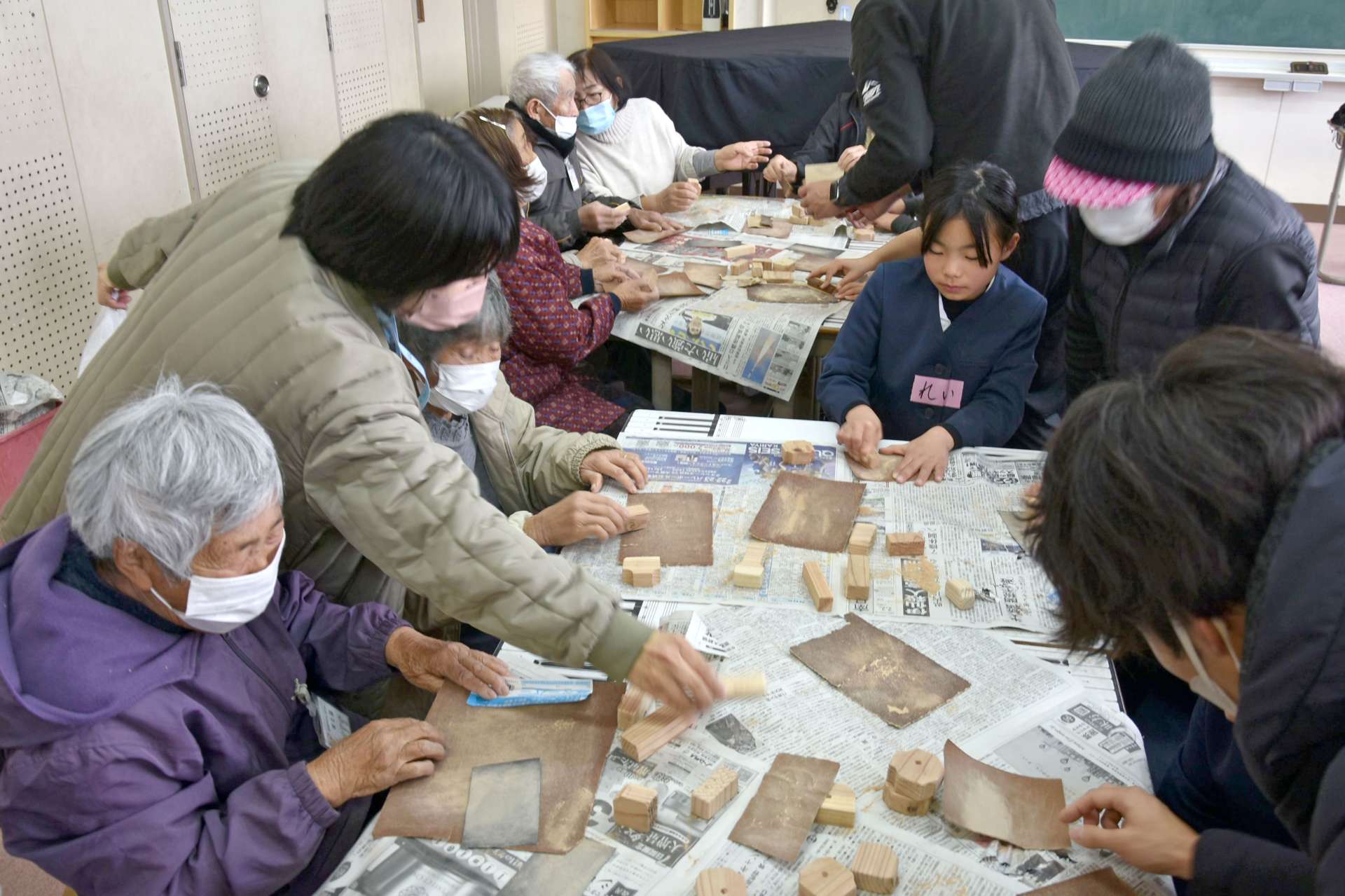 紙やすりで木を削る高齢者ら＝錦江町の大根占小学校