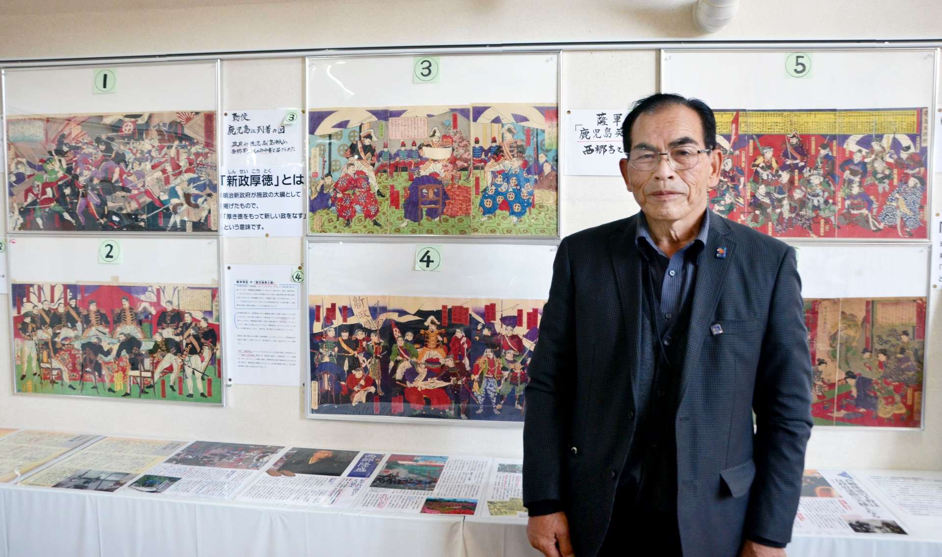 色鮮やかな西南戦争の錦絵と山下博明さん＝都城市の道の駅山之口