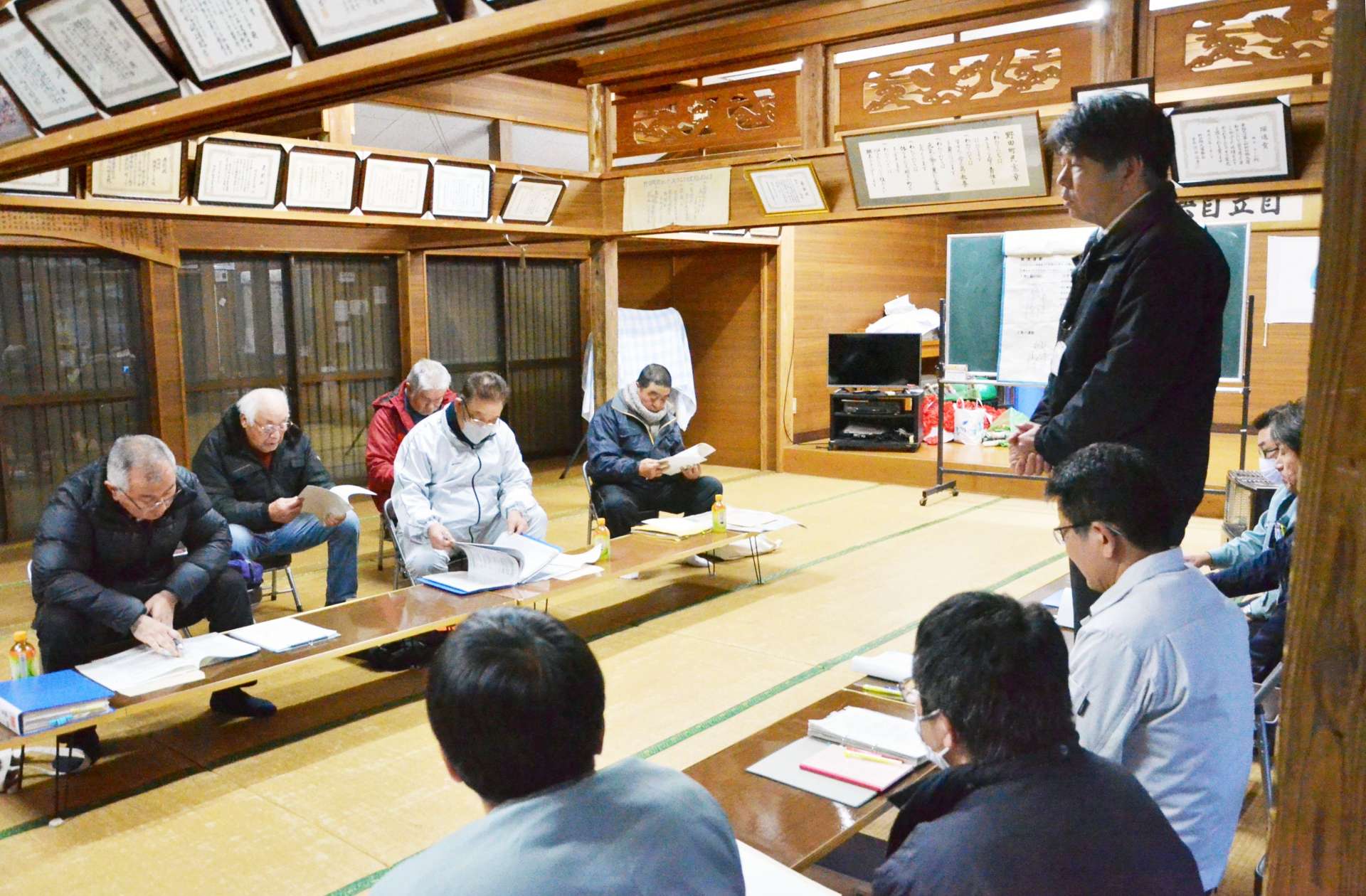 住民からの質問に対する知事の回答を説明する県職員（右）＝１３日、出水市