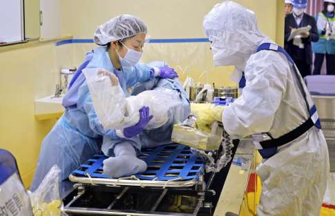 救護者に放射性物質が残っていないか計測器で確認する九電社員＝１４日、薩摩川内市の川内原発