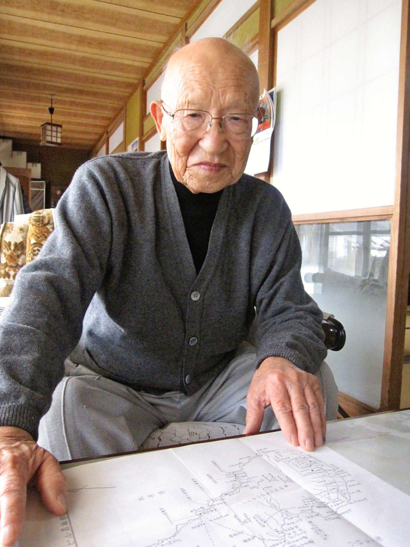 地図を指さしながら、当時の戦況を語る高橋龍雄さん＝日置市東市来