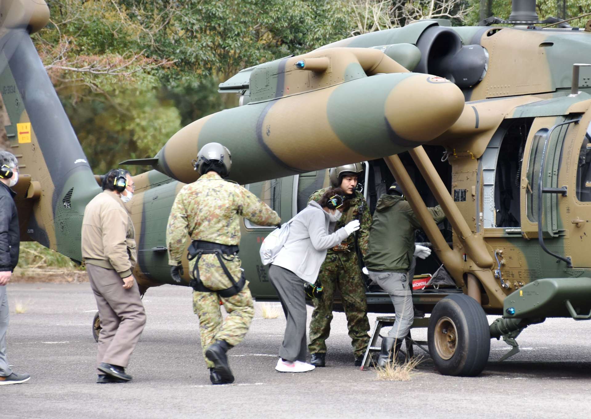 原子力総合防災訓練で自衛隊員の指示の下、ヘリコプターに乗り込む寄田地区の住民＝１５日午前１１時１０分ごろ、薩摩川内市