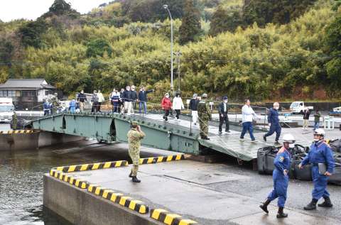 自衛隊が架けた橋を渡る羽島地区の住民＝１６日午前９時ごろ、いちき串木野市羽島