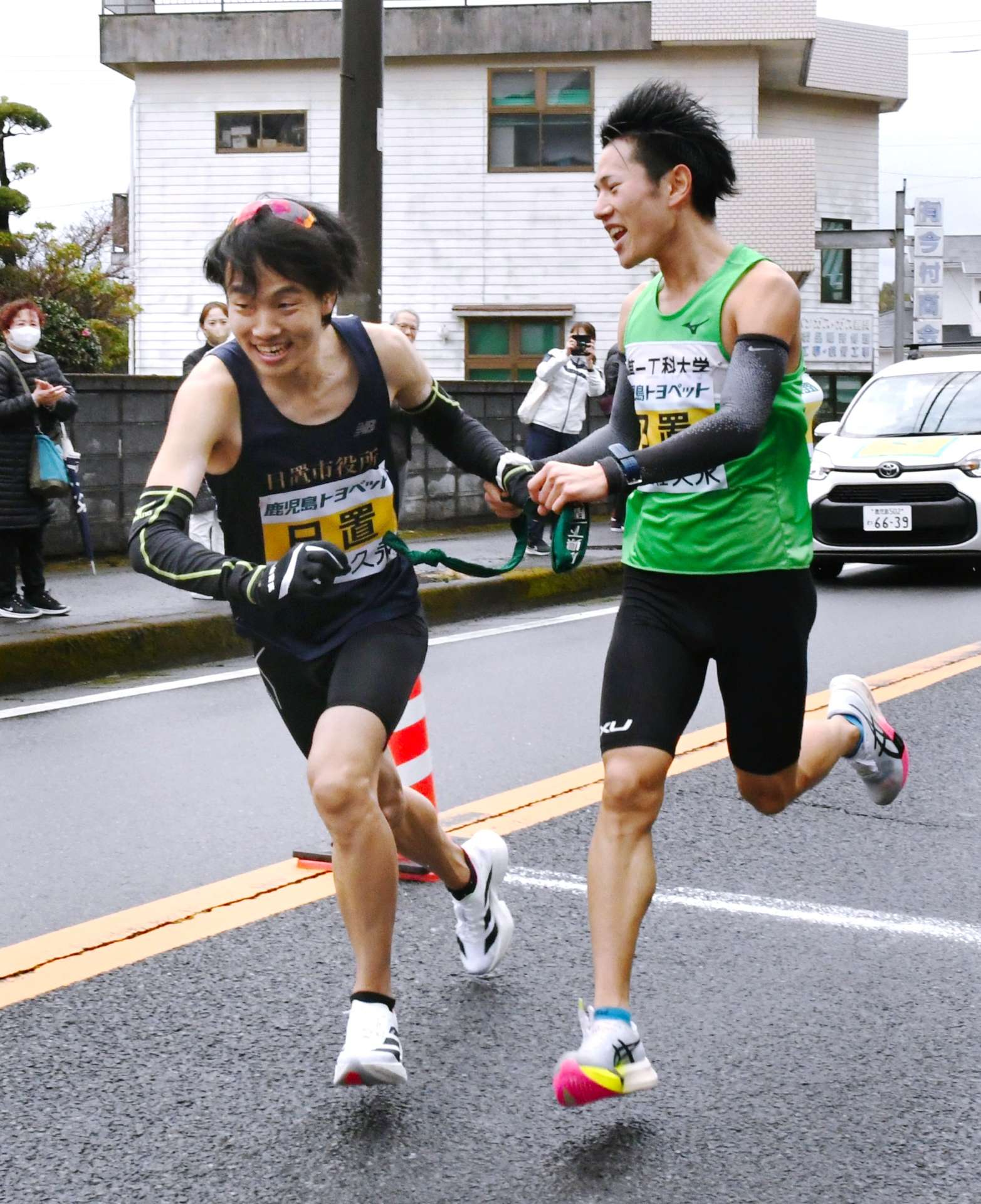 第２中継所、日置・東汰騎（右）から市来原潤にたすきが渡る＝日置市